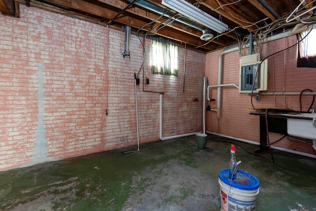 basement with electric panel and brick wall