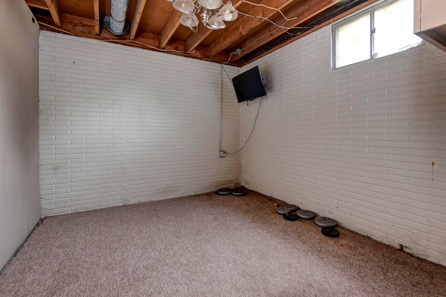 basement featuring brick wall and carpet floors