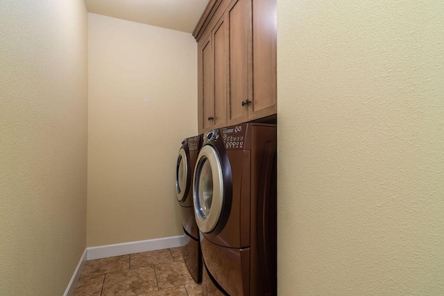 washroom featuring washer and clothes dryer and cabinets