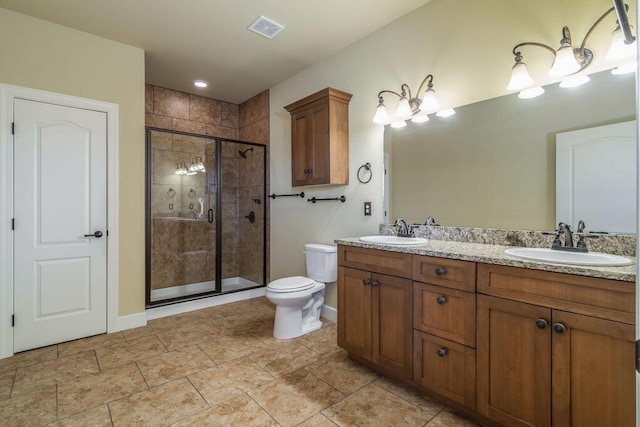 bathroom featuring vanity, toilet, and a shower with shower door