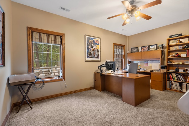 carpeted home office featuring ceiling fan