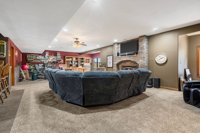 living room featuring a brick fireplace, carpet flooring, and ceiling fan