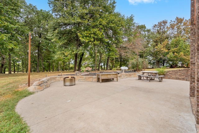 view of property's community featuring an outdoor fire pit and a patio area