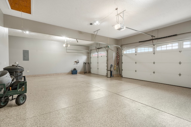 garage with a garage door opener and electric panel