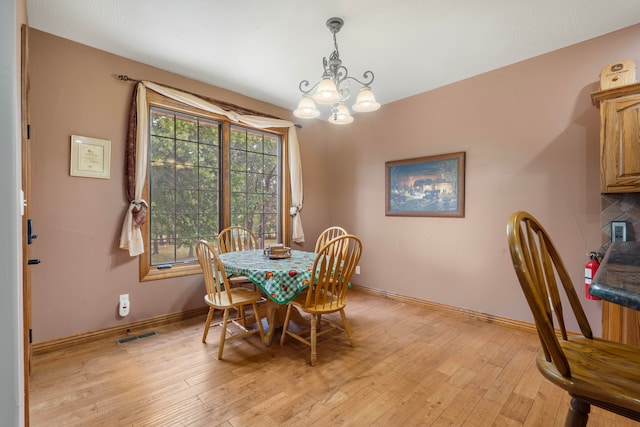 dining space with a chandelier and light hardwood / wood-style floors