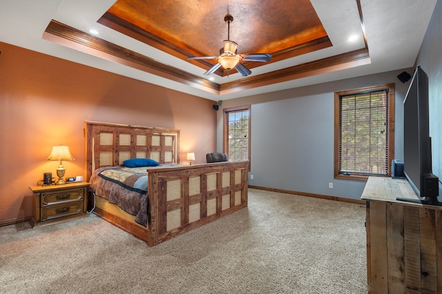 bedroom featuring ceiling fan, a tray ceiling, ornamental molding, and light carpet