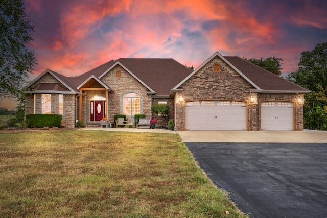 view of front of property featuring a garage and a lawn