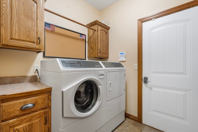 washroom with independent washer and dryer, light tile patterned floors, and cabinets