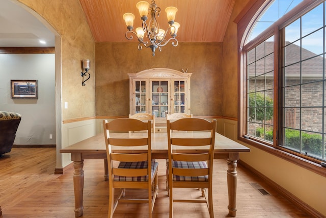 dining room with ornamental molding, wood ceiling, a chandelier, and light hardwood / wood-style floors