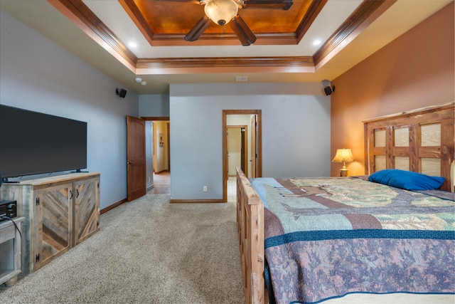 carpeted bedroom with crown molding, a tray ceiling, and ceiling fan