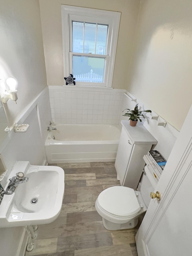 bathroom featuring sink, toilet, hardwood / wood-style flooring, and a bathing tub