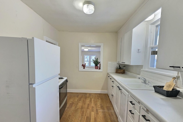 kitchen featuring white cabinets, white fridge, range with electric cooktop, and sink