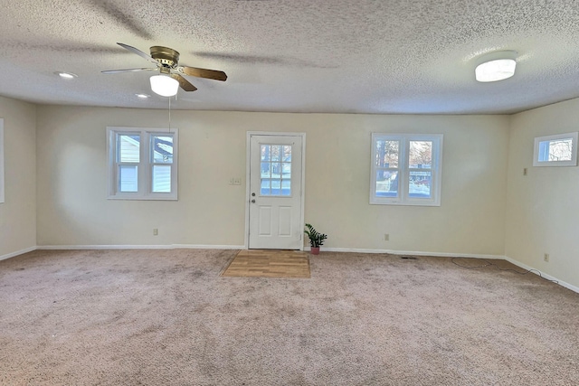 entrance foyer featuring a textured ceiling, carpet floors, and ceiling fan