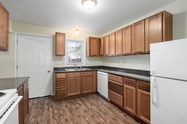 kitchen featuring dark wood-type flooring, sink, and white appliances