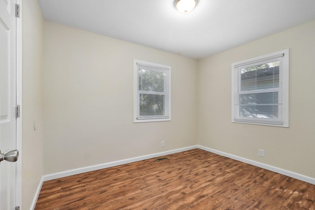 unfurnished room with hardwood / wood-style flooring and a wealth of natural light