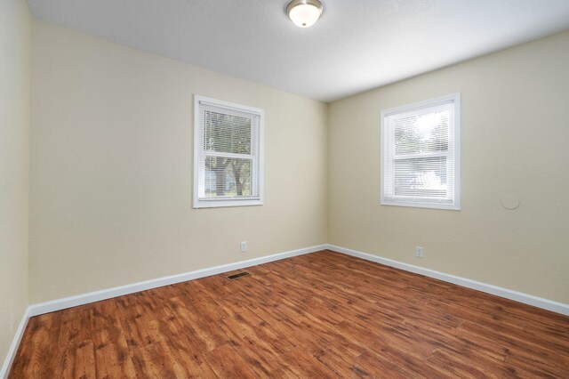 unfurnished room with hardwood / wood-style flooring