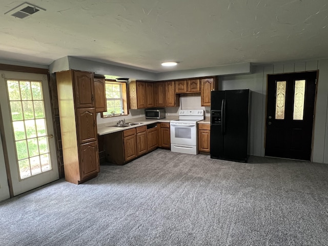 kitchen with light carpet, white range with electric cooktop, sink, and black refrigerator with ice dispenser