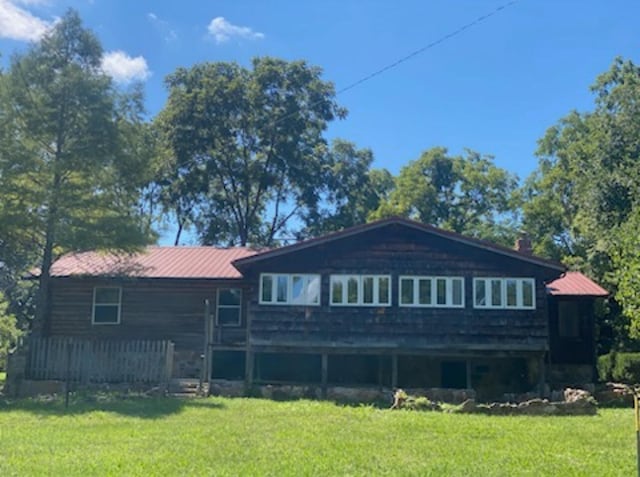 rear view of property featuring a lawn