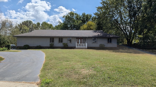 single story home featuring driveway, fence, and a front yard