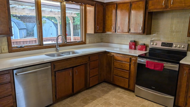 kitchen featuring appliances with stainless steel finishes, sink, and decorative backsplash