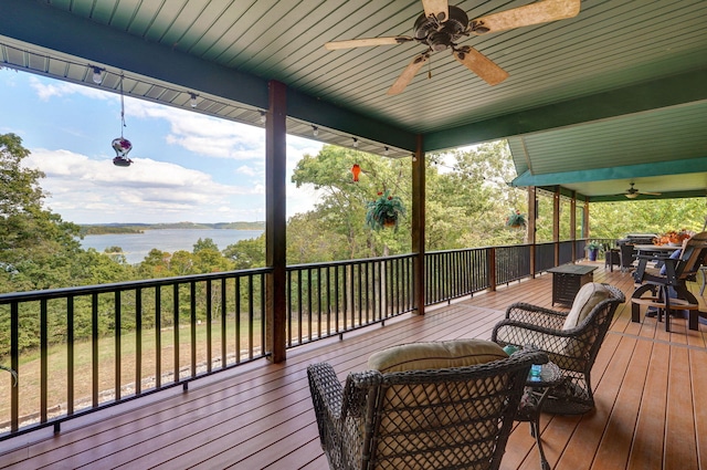 deck with a water view and ceiling fan