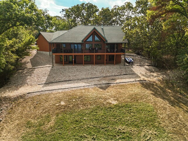 back of house with a deck and a patio