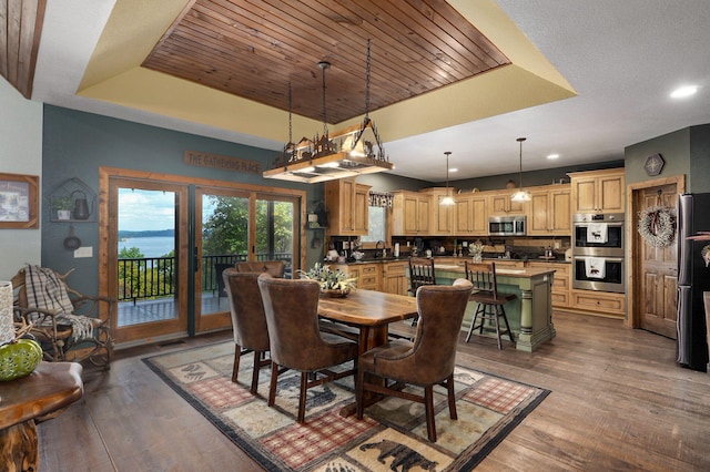 dining space with hardwood / wood-style flooring, a tray ceiling, and sink