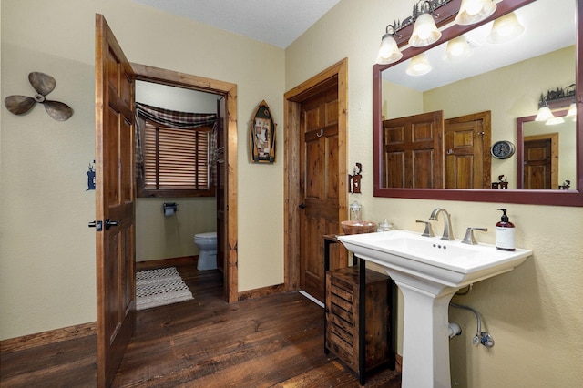 bathroom featuring sink, toilet, and wood-type flooring