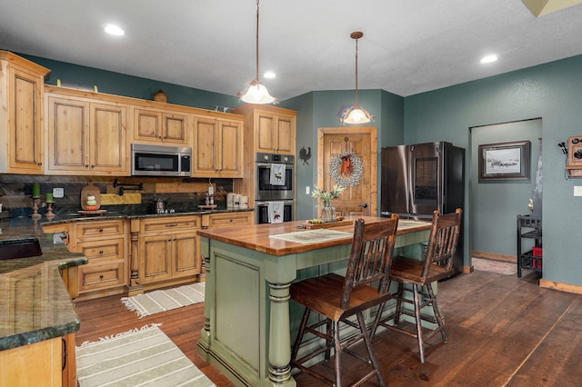 kitchen featuring tasteful backsplash, dark hardwood / wood-style floors, hanging light fixtures, appliances with stainless steel finishes, and a center island