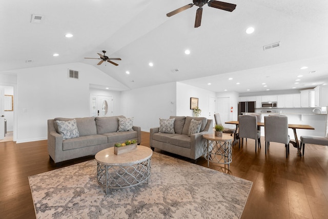 living room featuring ceiling fan, dark wood-type flooring, and vaulted ceiling