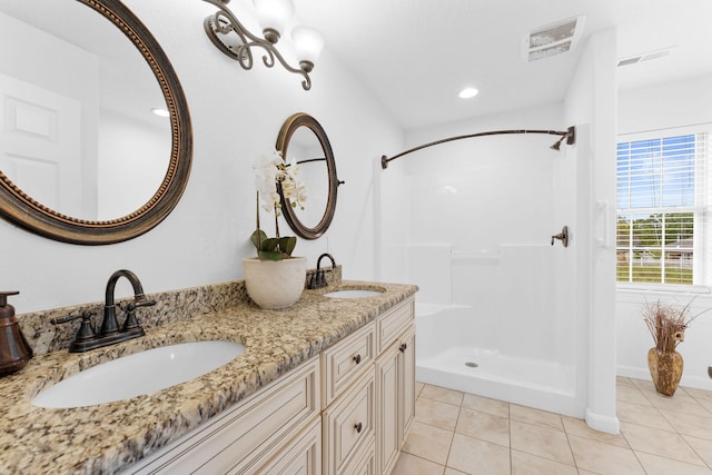 bathroom with tile patterned flooring, vanity, and a shower