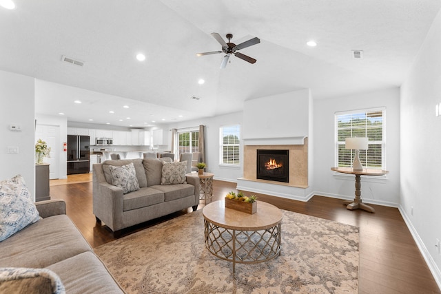 living room with dark hardwood / wood-style floors, vaulted ceiling, a wealth of natural light, and ceiling fan