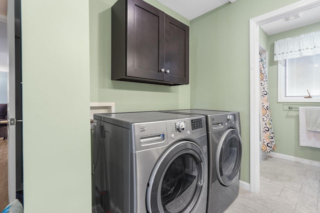 washroom featuring cabinets, light tile patterned flooring, and separate washer and dryer