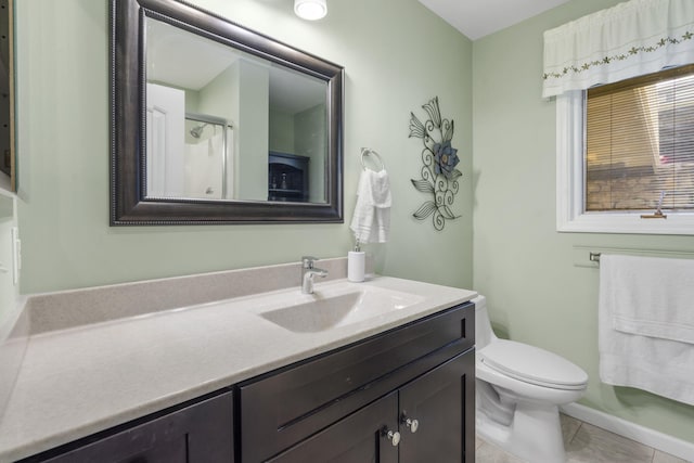 bathroom featuring vanity, a shower with shower door, toilet, and tile patterned floors