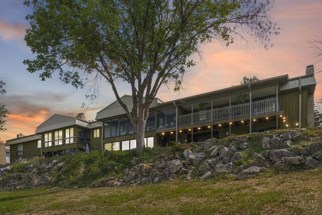 back house at dusk with a balcony