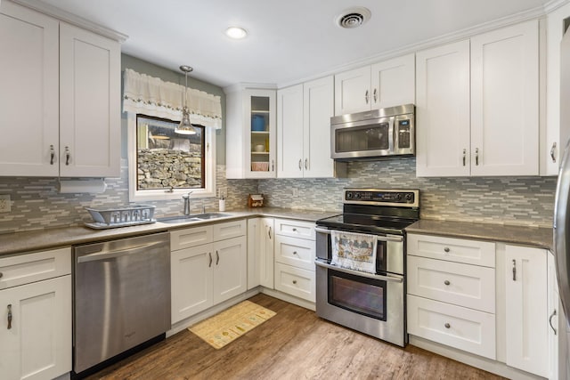 kitchen featuring backsplash, white cabinetry, sink, light hardwood / wood-style floors, and stainless steel appliances