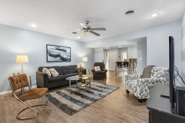 living room with light hardwood / wood-style flooring and ceiling fan