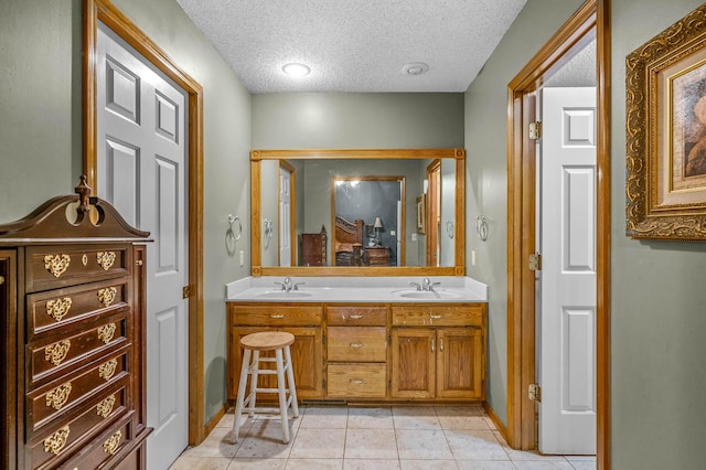 bathroom with vanity, tile patterned flooring, and a textured ceiling