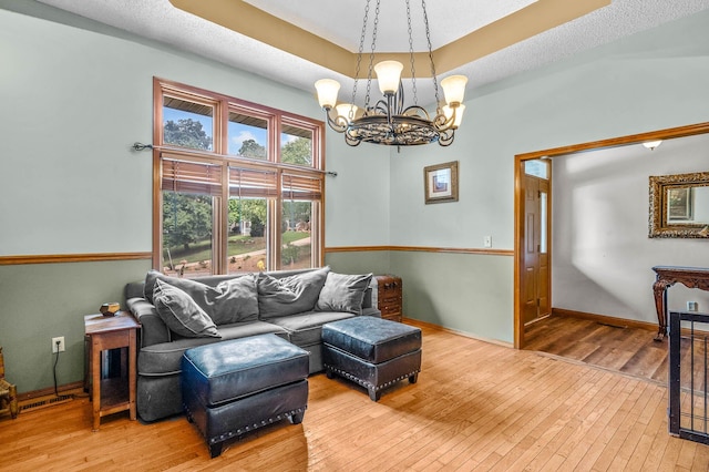 living room featuring a textured ceiling, a notable chandelier, and hardwood / wood-style flooring