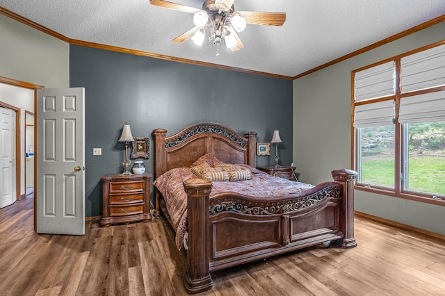 bedroom with crown molding, hardwood / wood-style floors, ceiling fan, and a textured ceiling