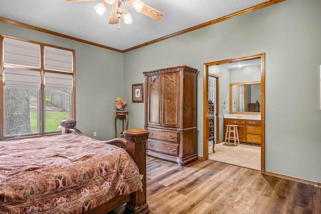 bedroom featuring light hardwood / wood-style floors, ensuite bathroom, ceiling fan, a textured ceiling, and crown molding