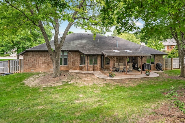 rear view of house featuring a yard and a patio