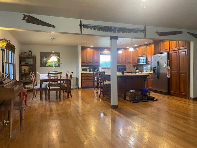 kitchen featuring stainless steel appliances, pendant lighting, and hardwood / wood-style floors