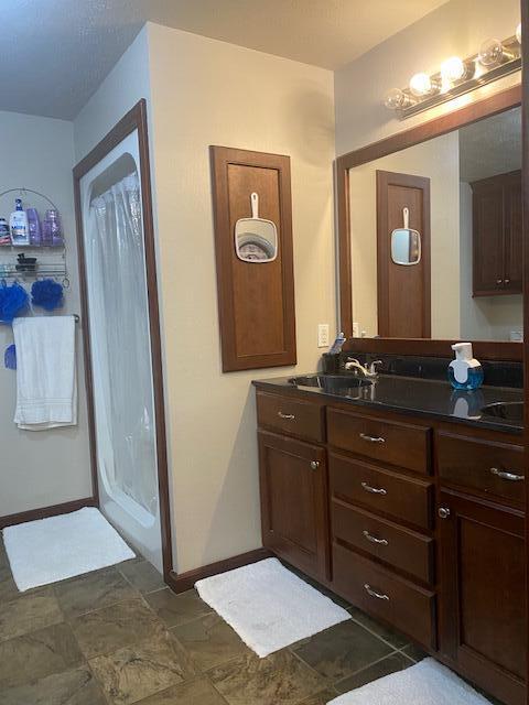 bathroom with walk in shower and vanity