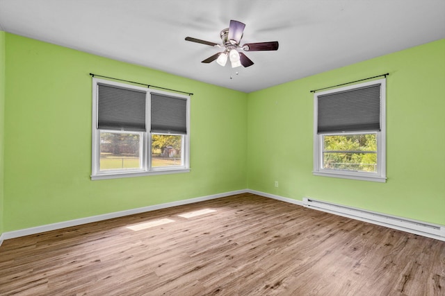 empty room with ceiling fan, a baseboard radiator, and light hardwood / wood-style floors