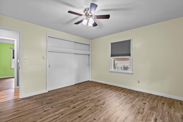 unfurnished bedroom featuring a closet, hardwood / wood-style floors, and ceiling fan