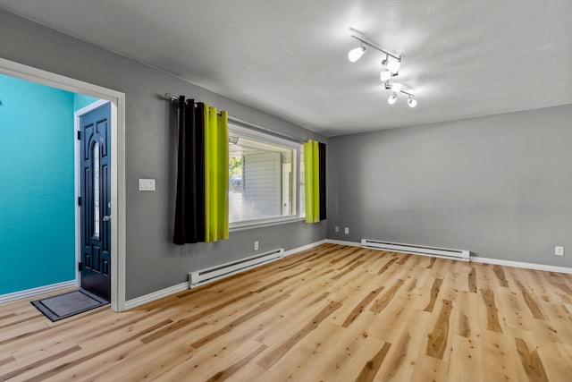 empty room featuring light hardwood / wood-style floors and a baseboard radiator