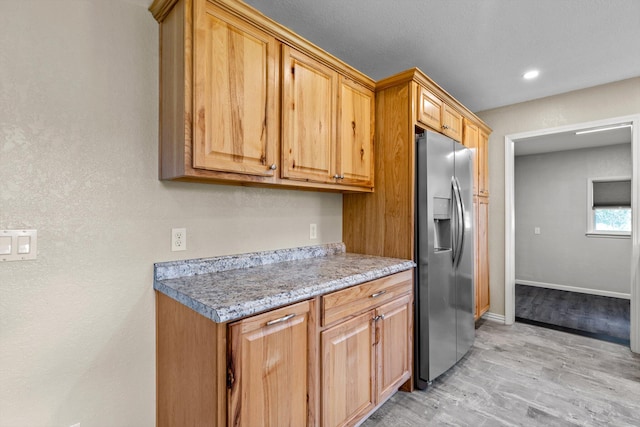 kitchen featuring light hardwood / wood-style flooring and stainless steel fridge