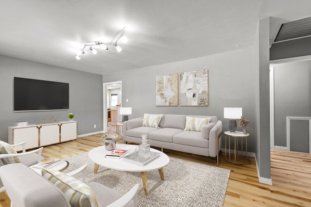 living room with wood-type flooring and a textured ceiling