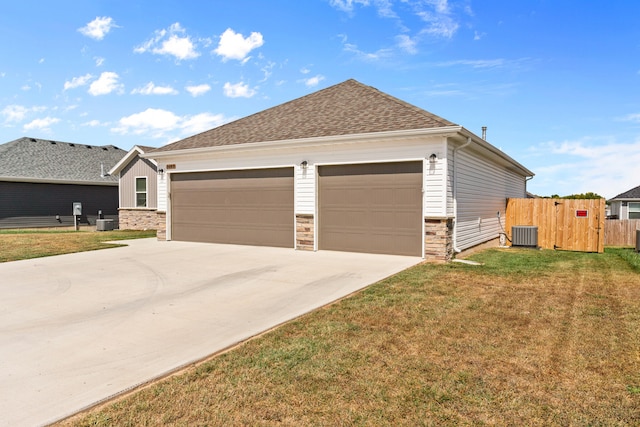 view of front of property with a front yard, cooling unit, and a garage